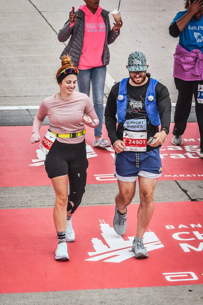 meghan wearing her neural sleeve crossing the finish line of the chicago marathon